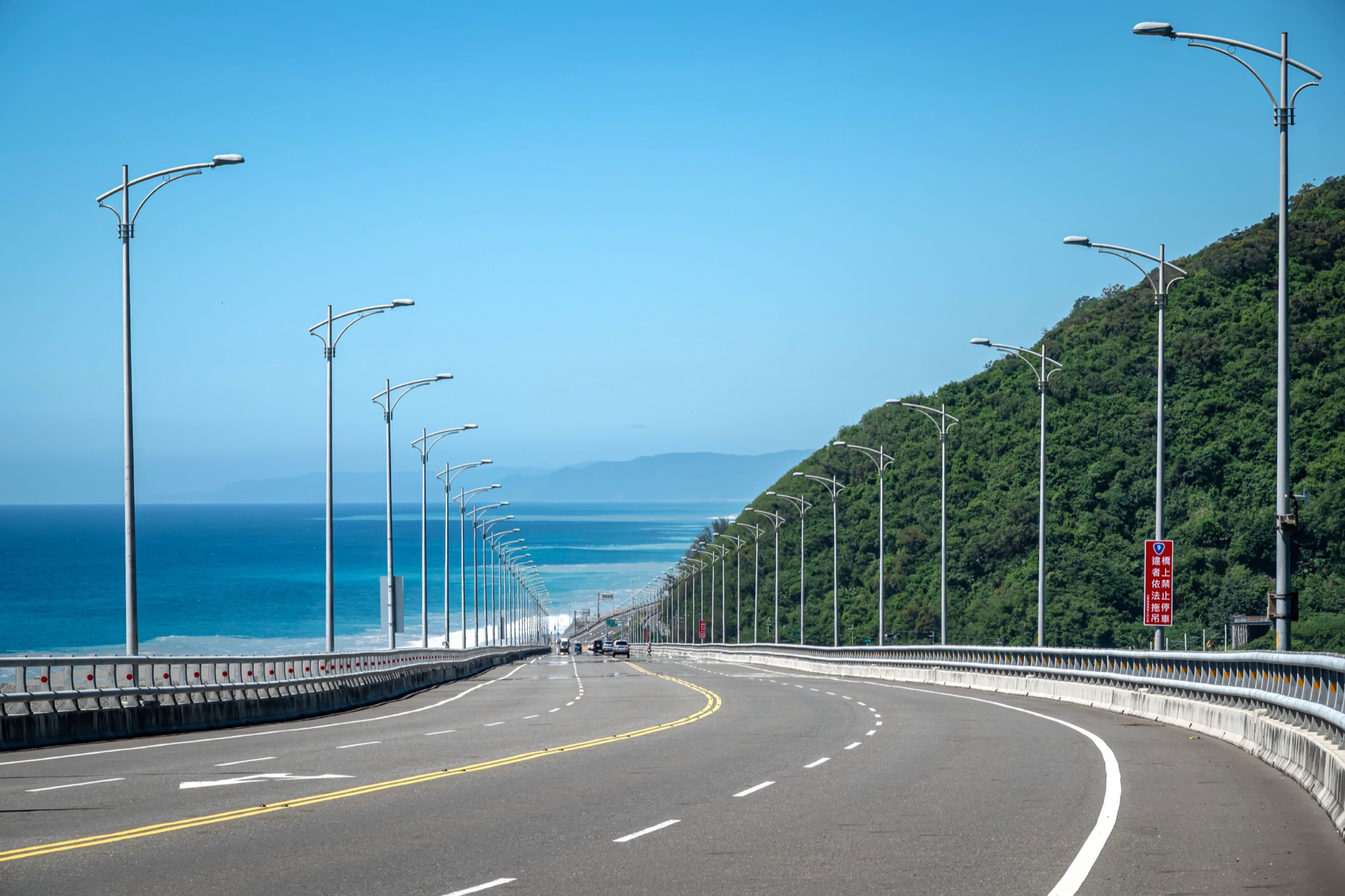 濱海公路沿著山腳往前延伸,左邊是深藍色的海